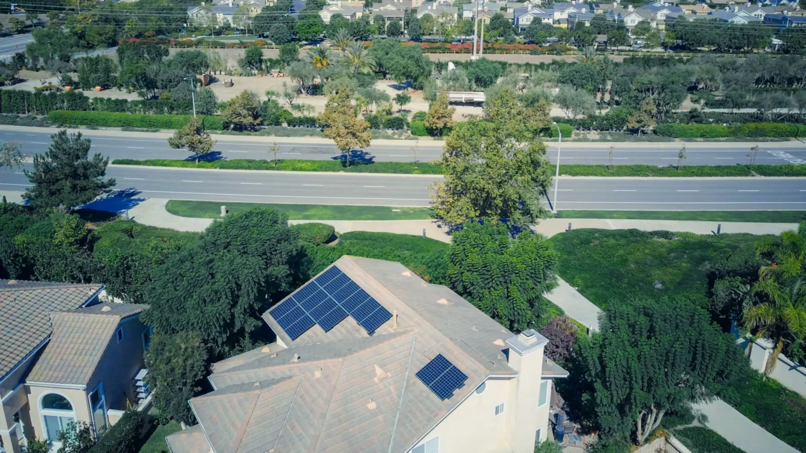 Vue aérienne d’un quartier résidentiel, avec au premier plan une maison équipée de panneaux solaires sur son toit